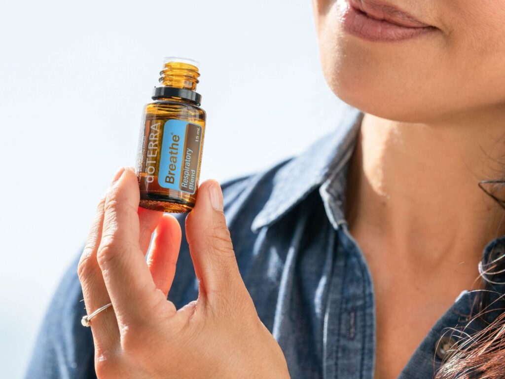 woman smelling a bottle of breathe essential oil