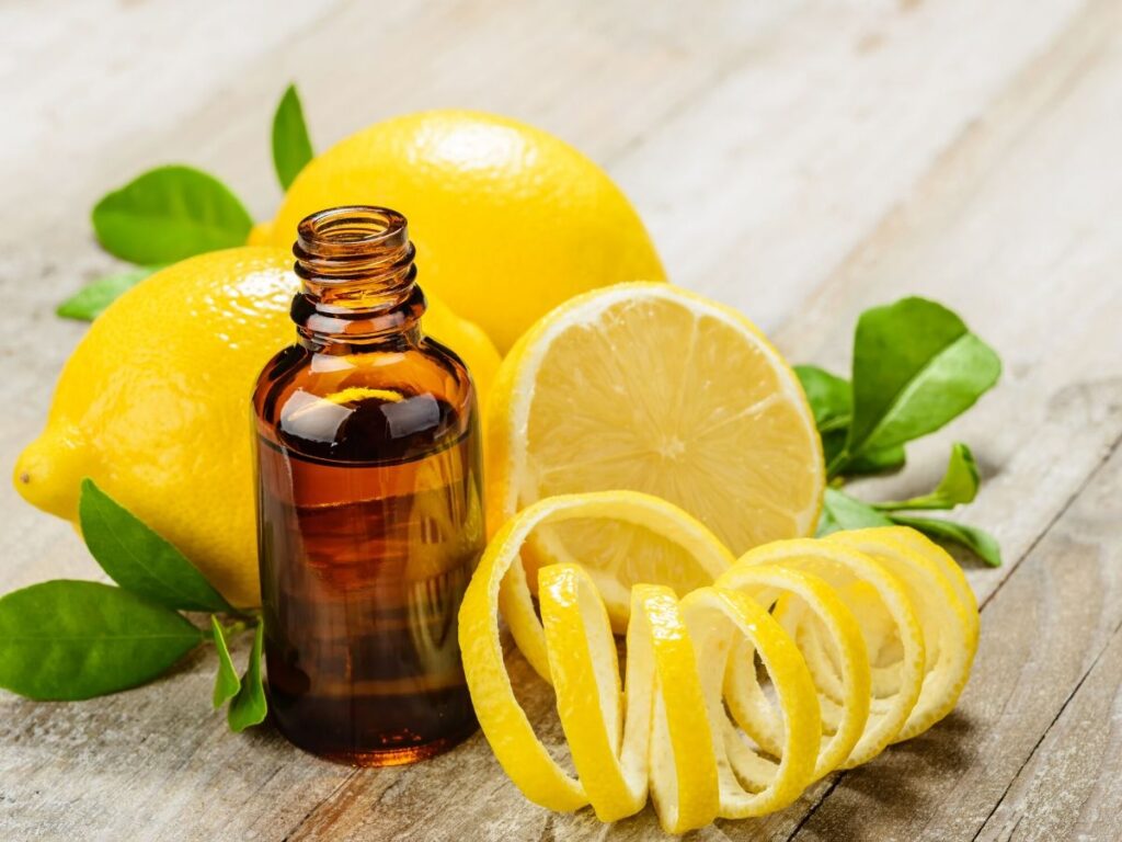 lemon essential oil with sliced lemon and peel