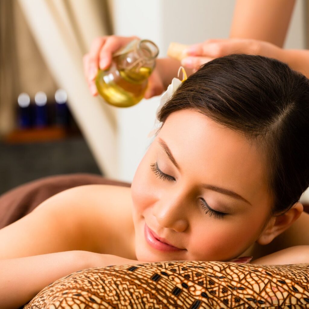 woman receiving an aromatherapy massaged with essential oils