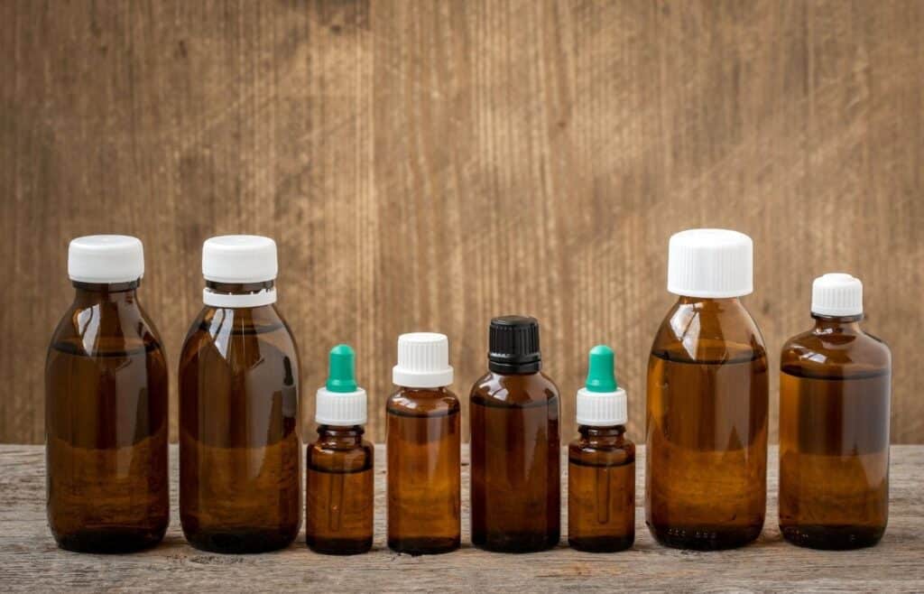 multiple amber colored essential oil bottles in different sizes on table