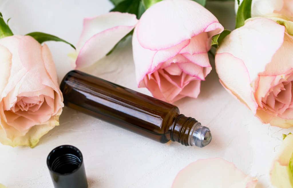 amber roller bottle blend on table with roses