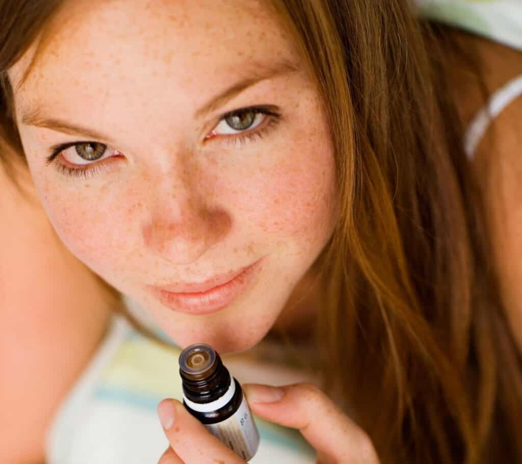  woman inhaling essential oils to promote health and wellness