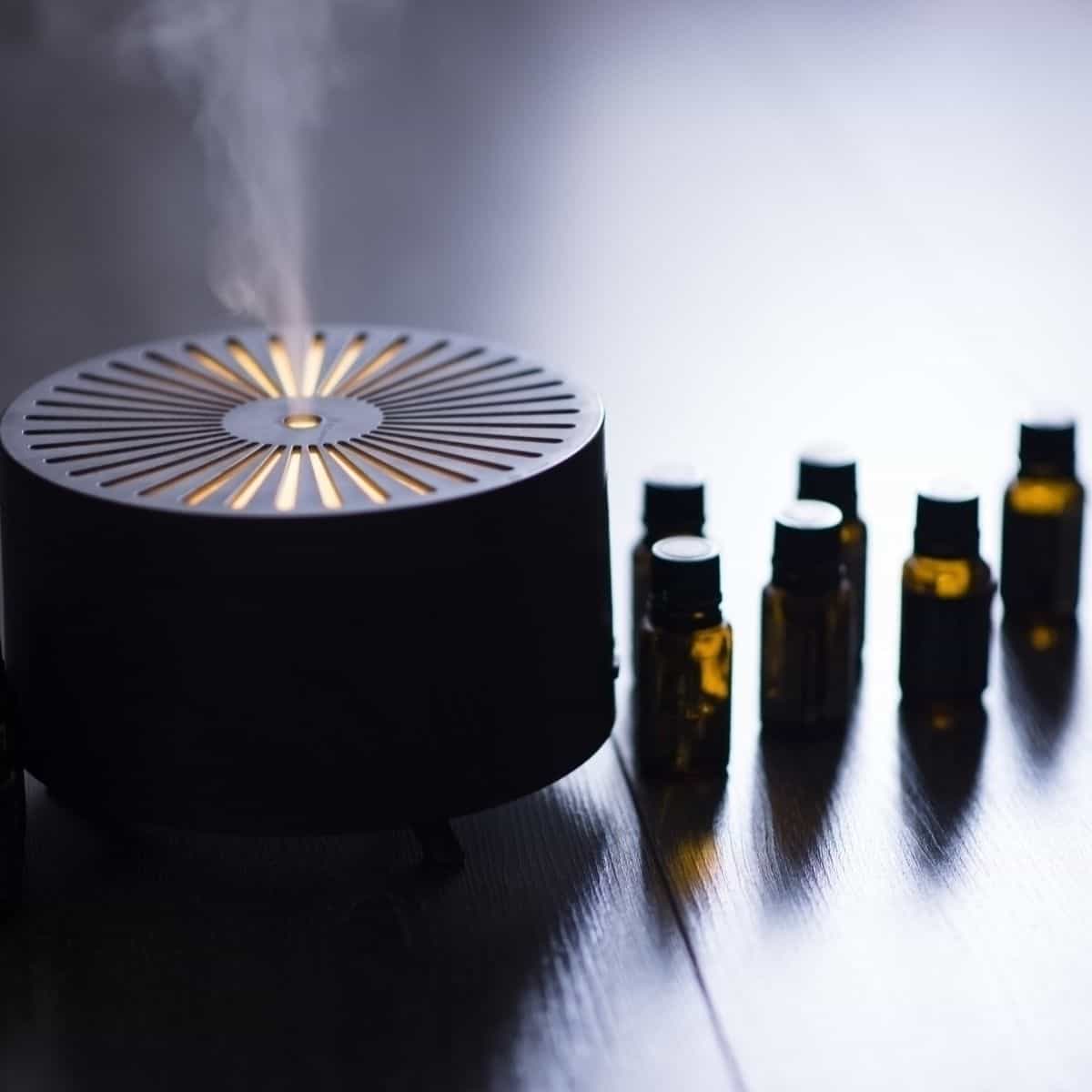 essential oil diffuser with essential oil bottles on table.