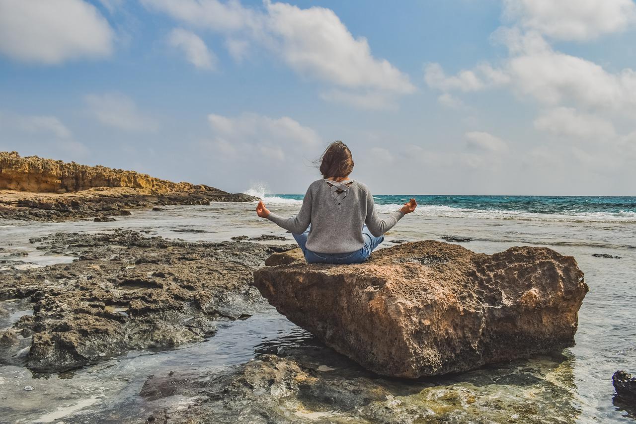 girl meditating on a rock.